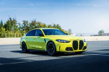 Brno, Çek Cumhuriyeti - 18 Ekim 2024: Hızlı lüks araba BMW M3 G80 ile açık sarı renkli park alanında duruyor.