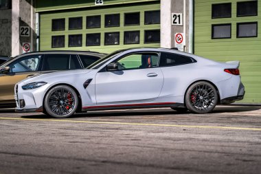 Brno, Çek Cumhuriyeti - 20 Ekim 2024: Gri renkli hızlı BMW M3 spor araba garajların önündeki yarış pistinde duruyor.