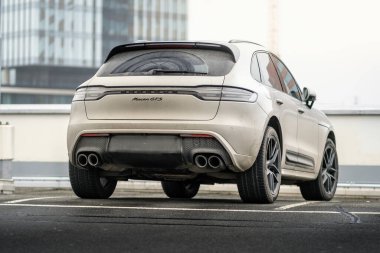 Brno, Çek Cumhuriyeti - 2 Aralık 2024: Gri Porsche Macan spor cipi bir mağazanın çatısına park edildi. Kirli lüks araba bir otoparkta..