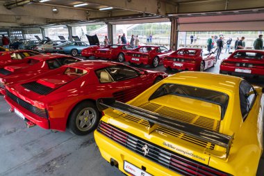 Brno, Çek Cumhuriyeti - 15 Ekim 2024: Koridorda park edilmiş bir sürü kırmızı pahalı İtalyan Ferrari arabası var. Lüks spor arabalar..