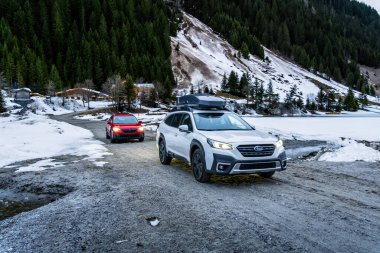 Alpler, Avusturya - 12 Mart 2024: Dağlarda bir kış gezisinde iki Subaru off-road otomobili. Japon SUV 'u kışın karda bir orman yolunda.