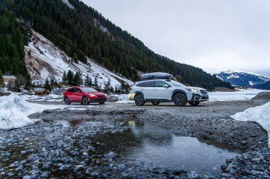 Alpler, Avusturya - 12 Mart 2024: Dağlarda bir kış gezisinde iki Subaru off-road otomobili. Japon SUV 'u kışın karda bir orman yolunda.