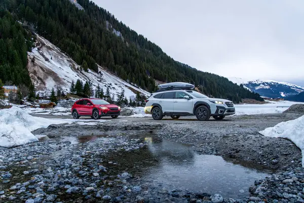 Alpler, Avusturya - 12 Mart 2024: Dağlarda bir kış gezisinde iki Subaru off-road otomobili. Japon SUV 'u kışın karda bir orman yolunda.