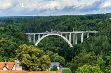 Demiryolu ve yol, Bechyn kasabasındaki iki tepe arasındaki derin bir vadinin üzerindeki kemerli köprü. Çek Cumhuriyeti, Lunice Nehri üzerindeki köprü.