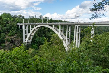 Demiryolu ve yol, Bechyn kasabasındaki iki tepe arasındaki derin bir vadinin üzerindeki kemerli köprü. Çek Cumhuriyeti, Lunice Nehri üzerindeki köprü.