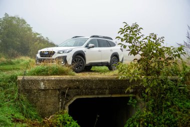 Güney Moravya, Çek Cumhuriyeti - 11 Kasım 2024: Beyaz modern SUV Subaru Outback sonbaharda siste bir arazide duruyor. Ailenin dört çeker off-road arabası..