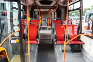 Brno, Çek Cumhuriyeti - 17 Temmuz 2024: Brno şehrinde bir toplu taşıma otobüsünün içi. Kırmızı koltuklu boş otobüs.