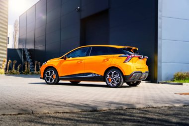 Güney Moravya, Çek Cumhuriyeti - 28 Mart 2025: Turuncu MG4 elektrikli araba endüstriyel bir bölgede. Çin 'de üretilen ünlü İngiliz markasının elektrik dostu SUV' si..