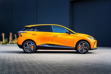 Güney Moravya, Çek Cumhuriyeti - 28 Mart 2025: Turuncu MG4 elektrikli araba endüstriyel bir bölgede. Çin 'de üretilen ünlü İngiliz markasının elektrik dostu SUV' si..