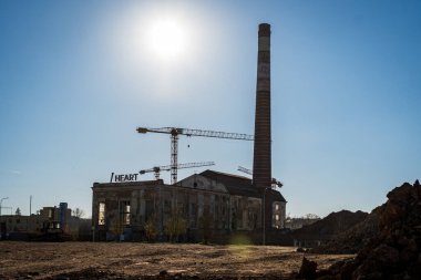 Uzun bacalı eski bir fabrika. Çek Cumhuriyeti 'nin Brno kentindeki eski bir sanayi bölgesinde harap bir bina. İnşaat alanı sabah güneşle aydınlandı..
