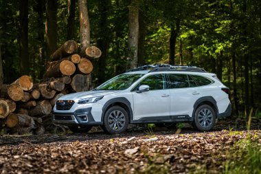 Güney Bohemya, Çek Cumhuriyeti - 12 Temmuz 2024: Beyaz aile arabası Subaru Outback ormandaki bir toprak yolda ağaçların arasında duruyor. Doğa gezisinde bir off-road arabası..