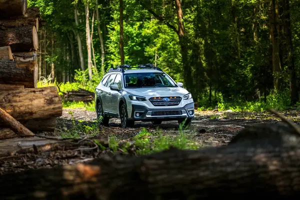Güney Bohemya, Çek Cumhuriyeti - 12 Temmuz 2024: Beyaz aile arabası Subaru Outback ormandaki bir toprak yolda ağaçların arasında duruyor. Doğa gezisinde bir off-road arabası..