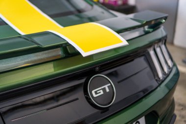 Brno, Çek Cumhuriyeti - 5 Mayıs 2025: Yeşil bir Ford Mustang spor arabasının montajına hazır sarı bir çıkartma. Bir arabaya vinil film etiketleri yerleştirmek.