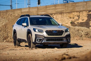 Brno, Çek Cumhuriyeti - 22 Nisan 2025: Bir inşaat alanında beyaz off-road SUV Subaru Outback. Japon arabası toprak yığınlarının yakınına park edilmiş..