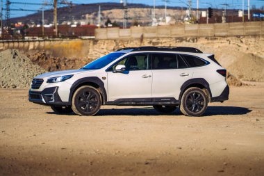 Brno, Çek Cumhuriyeti - 22 Nisan 2025: Bir inşaat alanında beyaz off-road SUV Subaru Outback. Japon arabası toprak yığınlarının yakınına park edilmiş..