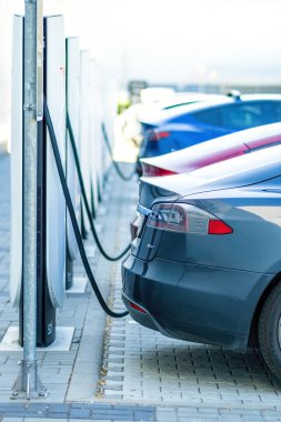 Brno, Çek Cumhuriyeti - 13 Mayıs 2025: Tesla elektrikli arabaları bataryayı elektrik enerjisiyle doldururken şarj istasyonlarına bağlandı.