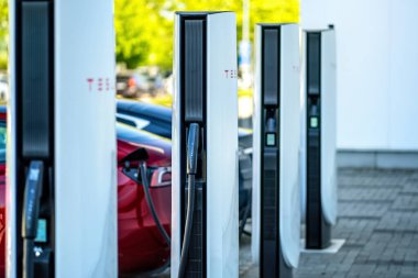 Brno, Çek Cumhuriyeti - 13 Mayıs 2025: Tesla otomobil şarj istasyonları. Elektrikli araba aküsü şarjı sırasında bağlı arabalı açık hava şarj cihazları..