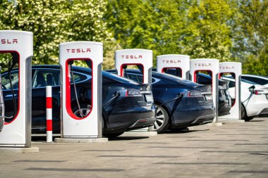 Brno, Çek Cumhuriyeti - 13 Mayıs 2025: Tesla otomobil şarj istasyonları. Elektrikli araba aküsü şarjı sırasında bağlı arabalı açık hava şarj cihazları..
