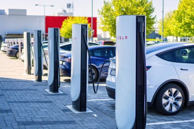 Brno, Çek Cumhuriyeti - 13 Mayıs 2025: Tesla otomobil şarj istasyonları. Elektrikli araba aküsü şarjı sırasında bağlı arabalı açık hava şarj cihazları..
