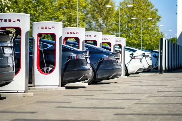 Brno, Çek Cumhuriyeti - 13 Mayıs 2025: Tesla elektrikli arabaları bataryayı elektrik enerjisiyle doldururken şarj istasyonlarına bağlandı.