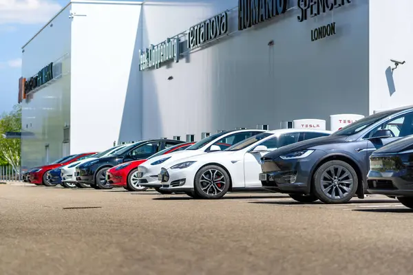 Brno, Çek Cumhuriyeti - 13 Mayıs 2025: Alışveriş merkezinin önünde bir sıra park edilmiş Tesla arabaları. Sahipleri alışveriş yaparken elektrikli arabalar pillerini şarj ediyor..