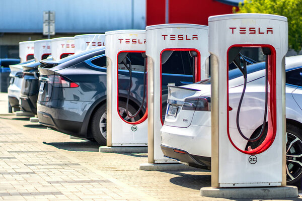 Брно, Чехия - 13 мая 2025 года: Зарядная станция для электромобилей Tesla. Ряд автомобилей, подключенных и заряжающих свои аккумуляторы.