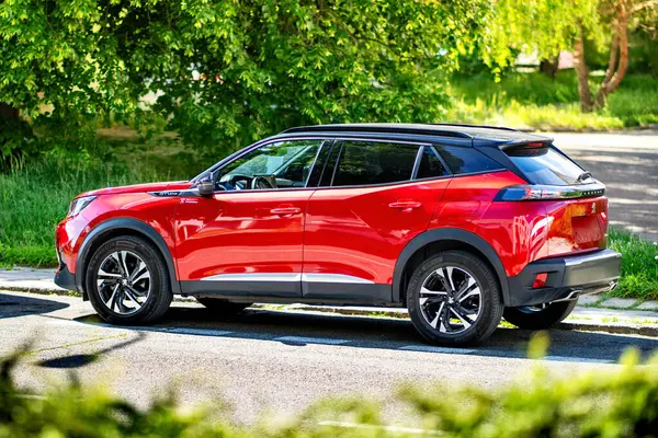 Brno, Çek Cumhuriyeti - 20 Mayıs 2025: Kırmızı yeni Peugeot 3008 baharda sokağa park edildi. Fransız yapımı yeni bir SUV. Kırmızı güzel modern araba..