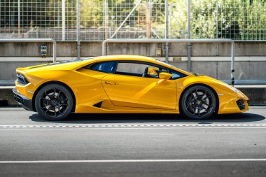 Brno, Çek Cumhuriyeti - 4 Eylül 2025: İtalyan süper spor otomobili Lamborghini Huracan yarış pistinin dışında duruyor. Parlak sarı renkli hızlı lüks araba..