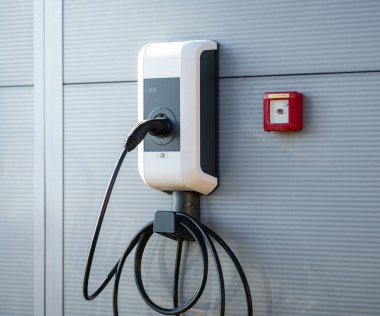 Elektrikli araba şarj istasyonu prizi. Güneş arabası şarj oluyor. Güneşten gelen temiz güç.