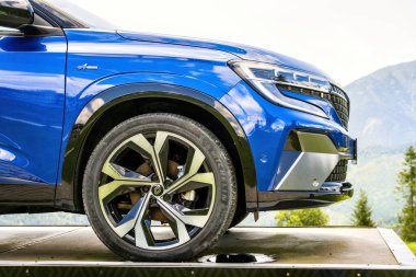 Tatra Dağları, Slovakya - 5 Ağustos 2024: Mavi modern SUV Renault Austral dağlarda sergileniyor. Ön tekerlek ve lastiğin ayrıntıları..