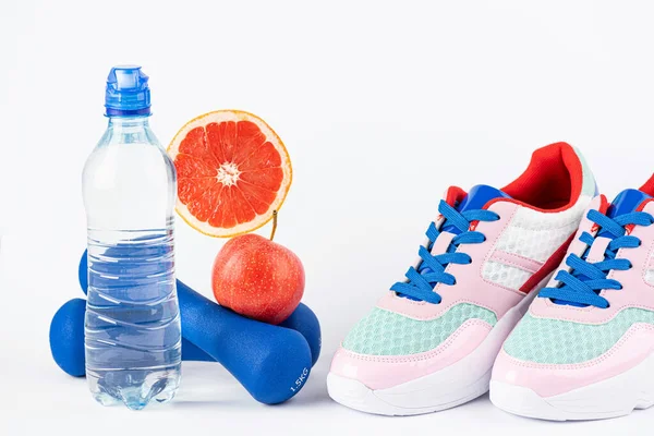 Sport background for fitness, healthy lifestyle, exercise, diet, healthy eating concept. Motivation sport card with sport equipment shoes, dumbbells, fruit and water bottle on white background. Copy spac