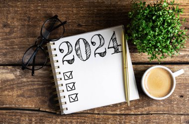 2024 sayılı yeni yıl kararları masada. 2024 gol listesi, defter, kahve fincanı, ahşap masa. Kararlar, plan, hedefler, eylem, kontrol listesi, fikir konsepti. Yeni Yıl 2024 kararları, kopyalama alanı