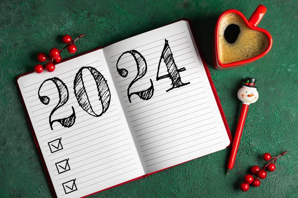 新年の決議2024が机の上に ノートブック付き2024ゴールリスト グリーンテーブルのコーヒーカップ チェックリスト アイデアコンセプト 新年2024決議 コピースペース — ストック写真
