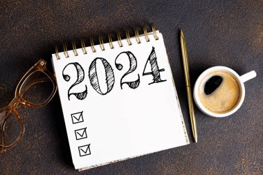 2024 sayılı yeni yıl kararları masada. 2024 gol listesi, defter, kahve fincanı, masa başında bitki. Kararlar, plan, hedefler, eylem, kontrol listesi, fikir konsepti. Yeni Yıl 2024 kararları, kopyalama alanı