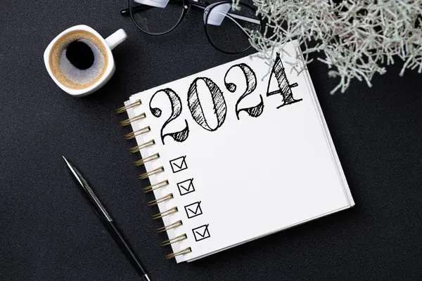 New year resolutions 2024 on desk. 2024 goals list with notebook, coffee cup, plant on black table. Resolutions, plan, goals, action, checklist, idea concept. New Year 2024 resolutions, copy space