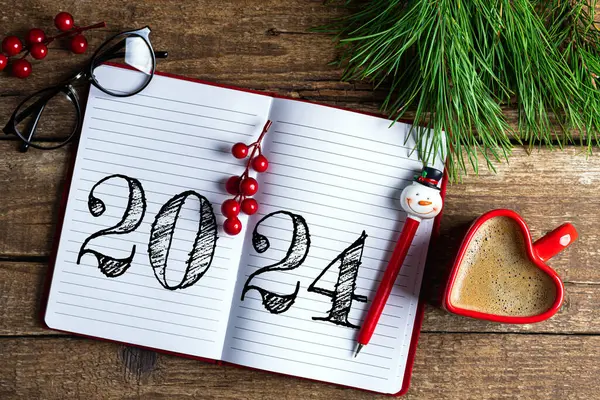 New year resolutions 2024 on desk. 2024 resolutions list with notebook, coffee cup on wooden table. Goals, resolutions, plan, action, checklist concept. New Year 2024 template, copy spac
