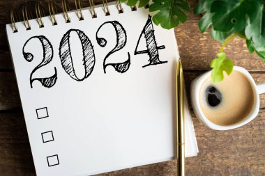 2024 sayılı yeni yıl kararları masada. 2024 gol listesi, defter, kahve fincanı, ahşap masa. Kararlar, plan, hedefler, eylem, kontrol listesi, fikir konsepti. Yeni yıl 2024 kararları. Boşluğu kopyala