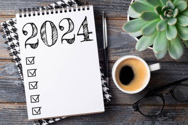 2024 sayılı yeni yıl kararları masada. 2024 gol listesi, defter, kahve fincanı, ahşap masa. Kararlar, plan, hedefler, eylem, kontrol listesi, fikir konsepti. Yeni yıl 2024 kararları. Boşluğu kopyala
