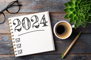 2024 sayılı yeni yıl kararları masada. Not defteri ve kahve fincanı olan 2024 karar listesi. Hedefler, çözümler, plan, eylem, kontrol listesi konsepti. Yeni Yıl 2024 şablon, kopyalama alanı