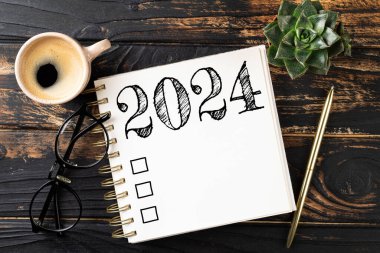 2024 sayılı yeni yıl kararları masada. Not defteri ve kahve fincanı olan 2024 karar listesi. Hedefler, çözümler, plan, eylem, kontrol listesi konsepti. Yeni Yıl 2024 şablon, kopyalama alanı
