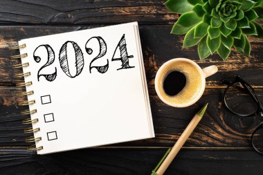 2024 sayılı yeni yıl kararları masada. 2024 gol listesi, defter, kahve fincanı, ahşap masa. Kararlar, plan, hedefler, eylem, kontrol listesi, fikir konsepti. Yeni yıl 2024 kararları. Boşluğu kopyala