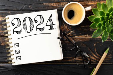 2024 sayılı yeni yıl kararları masada. 2024 gol listesi, defter, kahve fincanı, ahşap masa. Kararlar, plan, hedefler, eylem, kontrol listesi, fikir konsepti. Yeni yıl 2024 kararları. Boşluğu kopyala