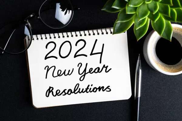 2024 New year resolutions on desk. 2024 goals list with notebook, coffee cup, plant on black table. Resolutions, plan, goals, action, idea concept. New Year 2024 resolutions. Copy space
