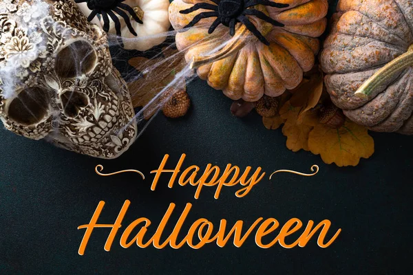 Happy Halloween card. Halloween background with pumpkins, spooky scull, autumn decorations on dark background. Happy Halloween concept