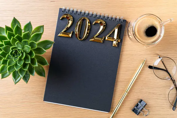 新しい年の決議2024机の上 2024年の目標は ノートブック コーヒーカップ 木製のテーブルの上の植物とリスト 解決策 チェックリスト アイデアコンセプト 2024年の解像度 コピースペース ストック画像