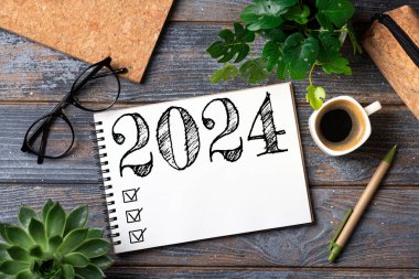 2024 sayılı yeni yıl kararları masada. 2024 gol listesi, defter, kahve fincanı, ahşap masa. Kararlar, plan, hedefler, eylem, kontrol listesi, fikir konsepti. Yeni Yıl 2024 Kararları