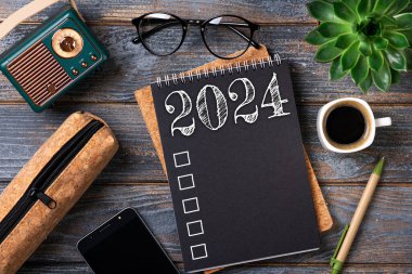 2024 sayılı yeni yıl kararları masada. 2024 gol listesi, defter, kahve fincanı, ahşap masa. Kararlar, plan, hedefler, eylem, kontrol listesi, fikir konsepti. Yeni Yıl 2024 Kararları