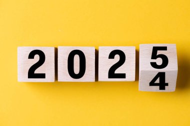 2025 mutlu yıllar. 2024 'ten 2025' e kadar mavi üzerine tahta blok değişimi. 2025 'in yeni yıl geçmişi. İş, kararlar, hedefler, ilham, başarı, fikirler