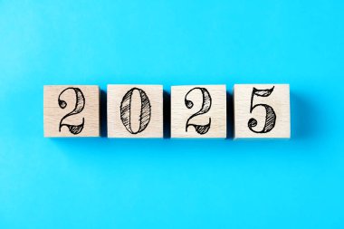 2025 mutlu yıllar. 2025 nolu tahta küp masa. 2025 'in yeni yıl geçmişi. İş, kararlar, hedefler, ilham, başarı, fikirler