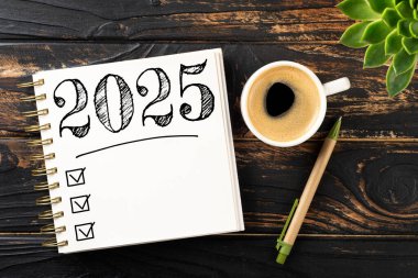 New year resolutions 2025 on desk. 2025 goals list with notebook, coffee cup, plant on wooden table. Resolutions, plan, goals, action, checklist, idea concept. New Year 2025 resolutions. Copy space clipart